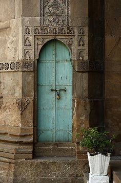 an old building with a blue door and planter