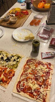 two pizzas are sitting on the table ready to be cooked and put in the oven