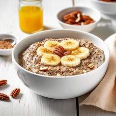 a bowl of oatmeal with bananas and pecans on the side, surrounded by nuts