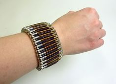 a woman's arm wearing a bracelet with multiple rows of different colored beads on it