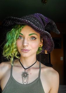 a woman with green hair wearing a black hat