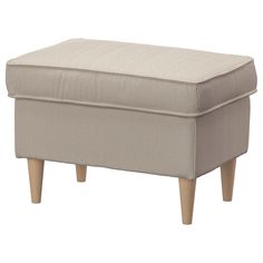 an ottoman with wooden legs and a beige upholstered cover on the bottom side