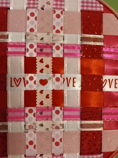 a red and white patchwork plate with words on it that say love in different languages