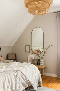 a bedroom with a bed and mirror on the wall