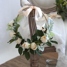 a wreath on top of a chair with white flowers and greenery around the edges