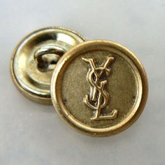 a gold colored button with the letter y on it's side and an image of a st louis