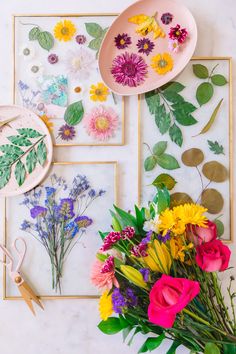 colorful flowers are displayed on the wall next to framed pictures and paper cutting tools with scissors