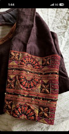 an old purse sitting on top of a bed next to a blanket and pillow cover