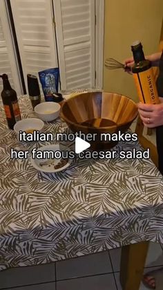 a woman is pouring wine into a bowl on top of a table with plates and utensils