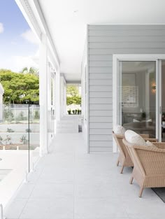 an outdoor patio with chairs and tables on the front porch, overlooking a swimming pool