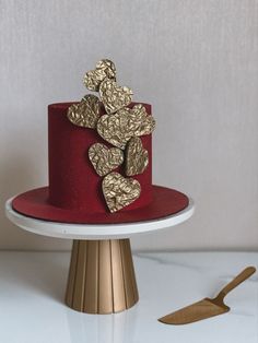 a red cake with gold hearts on top