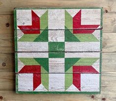 a wooden block with red, green and white stars on it