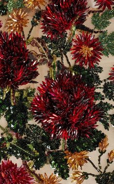 red flowers and green leaves on a white fabric with sequins in the center