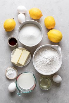 ingredients to make lemon cake laid out on a gray surface with eggs, butter and flour