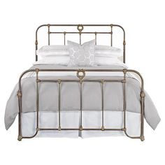 an iron bed frame with white sheets and pillows