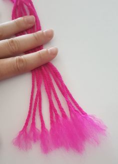 a hand is shown with pink yarn on it