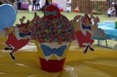 there is a cup that has candy in it and some decorations on the table behind it