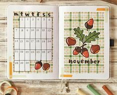 an open planner book sitting on top of a wooden table next to scissors and pencils