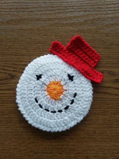 a crocheted snowman ornament with a red hat on it's head