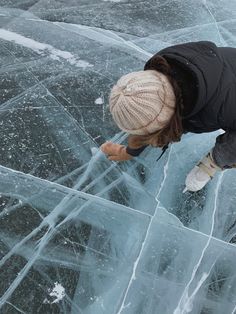 a woman standing on top of an ice covered ground