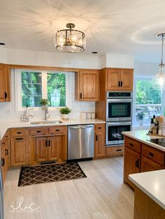 a kitchen with wooden cabinets and stainless steel appliances in the middle of an open floor plan