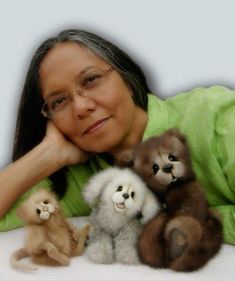 a woman laying on top of a bed next to small stuffed animals in front of her