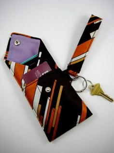 an orange, black and white tie has a keychain attached to it as well