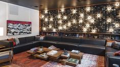 a living room filled with furniture and lots of lights on the wall above it's bookshelf