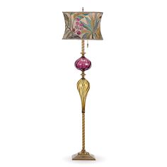 a lamp that is sitting on top of a table next to a light fixture with a flowered shade