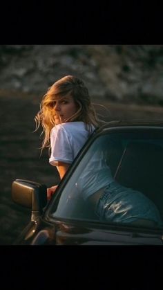 a woman leaning out the window of a car