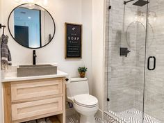 a bathroom with a toilet, sink, and shower in it's own area