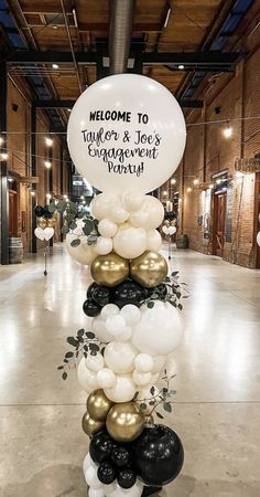 balloons are arranged in the shape of a tower with welcome to taylor and jolie's engagement party sign