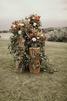 Fall colored floral on a set of three logs at a ceremony location in montana Rusty Red Wedding, Sage And Copper Wedding, Terracotta Sage Wedding, Sage Green And Rust Wedding, Sage And Rust Wedding, Rust And Sage Green Wedding, Sage Green And Terracotta Wedding, Rust And Sage Wedding, Wedding In Montana