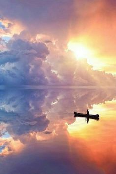 an airplane is flying in the sky with clouds and sun shining through it's reflection