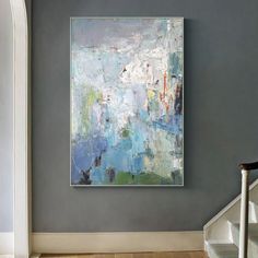 an abstract painting hangs on the wall next to a stair case and handrails