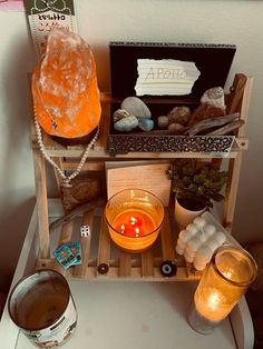 a shelf with candles, rocks and other items on it