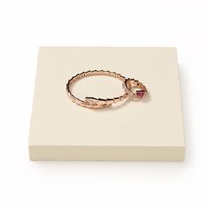 a pink ring sitting on top of a white box