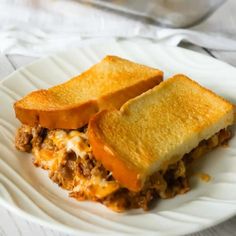 two slices of cheese and meat sandwich on a white plate