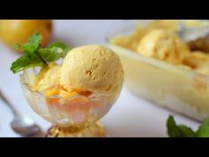 two scoops of ice cream in a glass dish with mint sprig on top