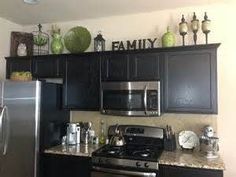 a kitchen with black cabinets and stainless steel appliances