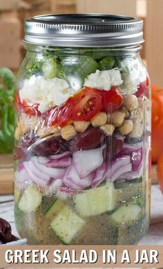 a mason jar filled with greek salad in a jar