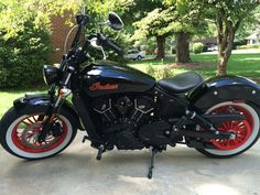 a black and red motorcycle is parked on the sidewalk