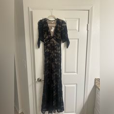 a black dress hanging on a door with a hanger in front of the door