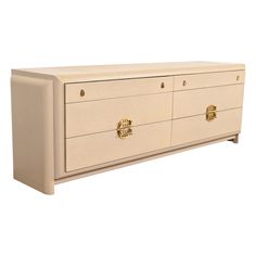 a white dresser with gold handles and drawers