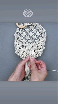 someone is crocheting a white object with yarn