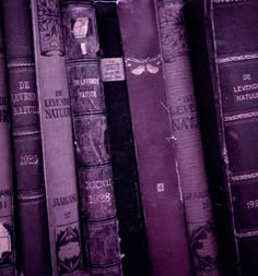 old books are lined up in rows on the shelf, and one has a butterfly on it