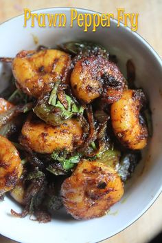 a white bowl filled with fried vegetables on top of a table