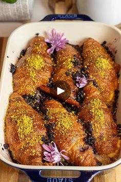 a casserole dish filled with croissants covered in yellow and purple sprinkles