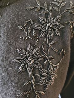 the back of a jacket with embroidered flowers on it