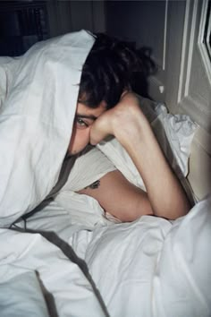 a woman laying in bed under a blanket with the caption he's not very fondd of me taking pictures of him when he wakes up